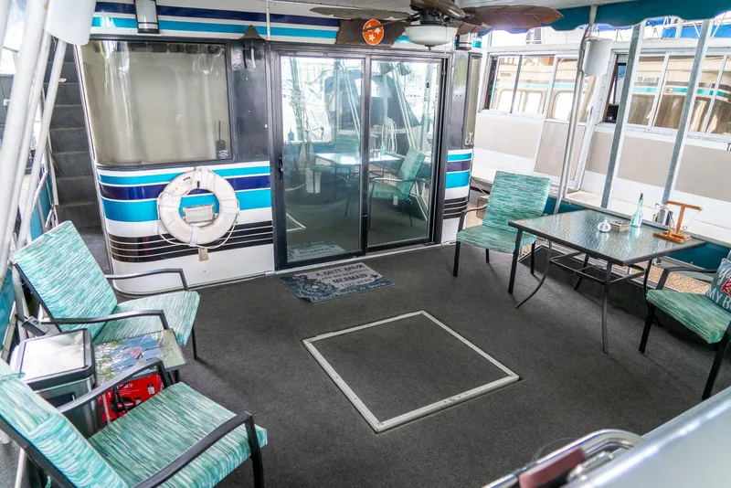 Slide: The Image of 1991 Sumerset 65 x 14 Widebody Houseboat interior with seating area and glass doors. - 31