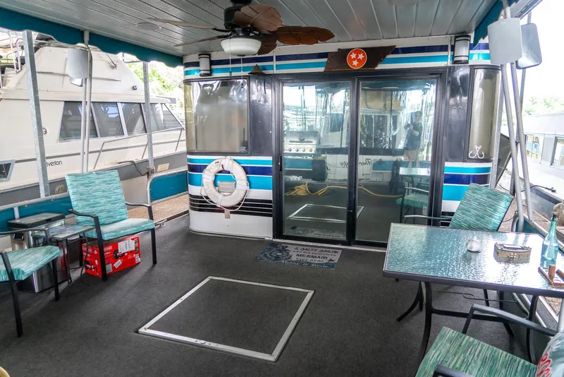 Slide: The Image of 1991 Sumerset 65 x 14 Widebody Houseboat interior with seating, table, and life preserver. - 32