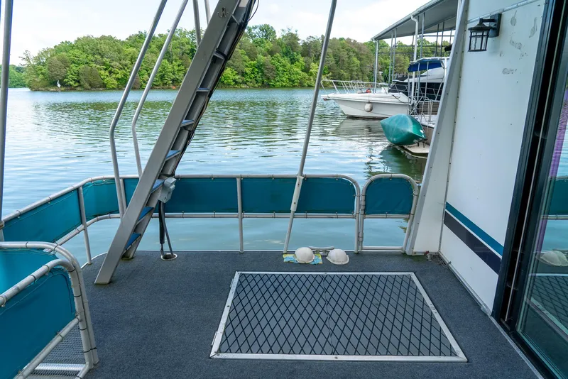 Slide: The Image of 1991 Sumerset 65 x 14 Widebody Houseboat deck with lake view and docked boats. - 39