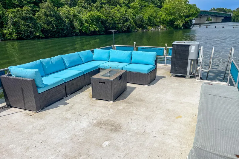 Slide: The Image of 1991 Sumerset 65 x 14 Widebody Houseboat deck with blue outdoor seating and water view. - 44