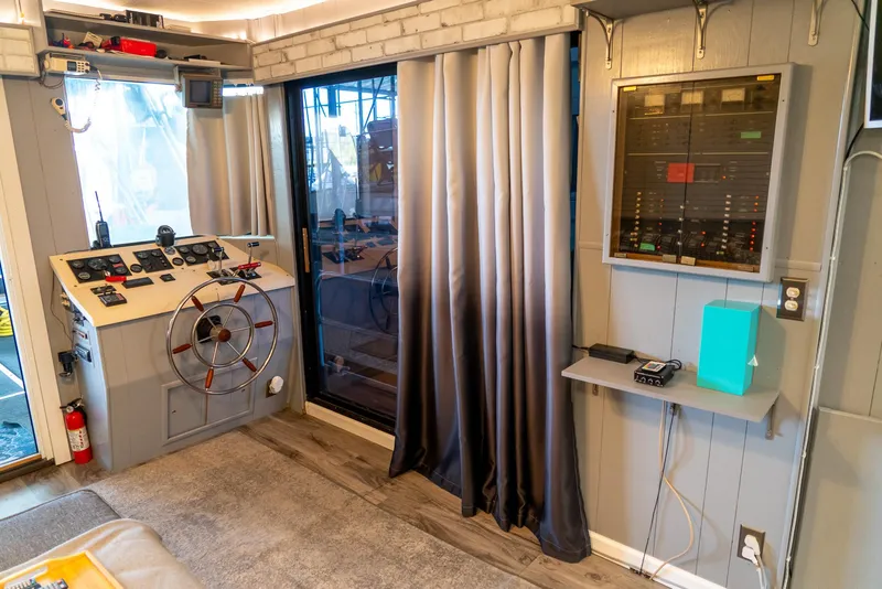 Slide: The Image of 1991 Sumerset 65 x 14 Widebody Houseboat interior with helm, control panel, and modern decor. - 6