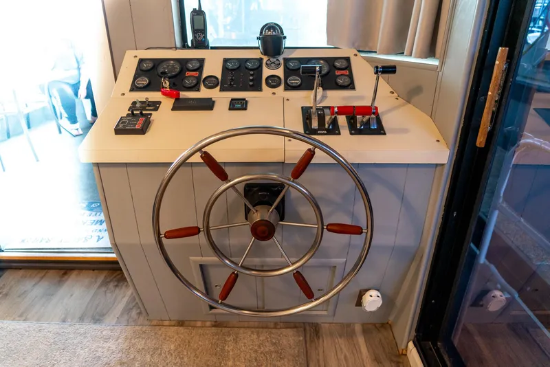 Slide: The Image of 1991 Sumerset 65 x 14 Widebody Houseboat helm with steering wheel and control panel. - 7