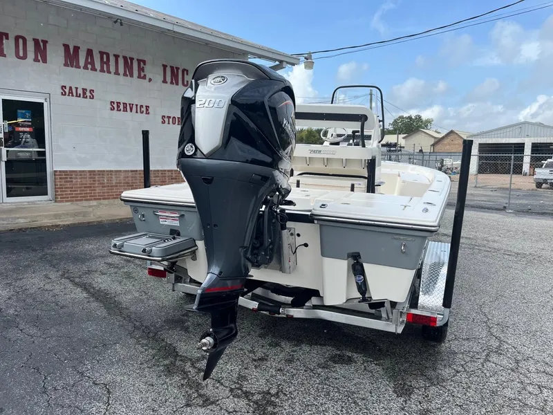 Slide: The Image of 2024 Pathfinder 2200 TRS boat with outboard motor at a marine dealership. - 2