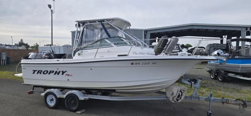 Slide: The Image of 2008 Trophy 2152WA boat on trailer, parked outdoors near a storage facility. - 0
