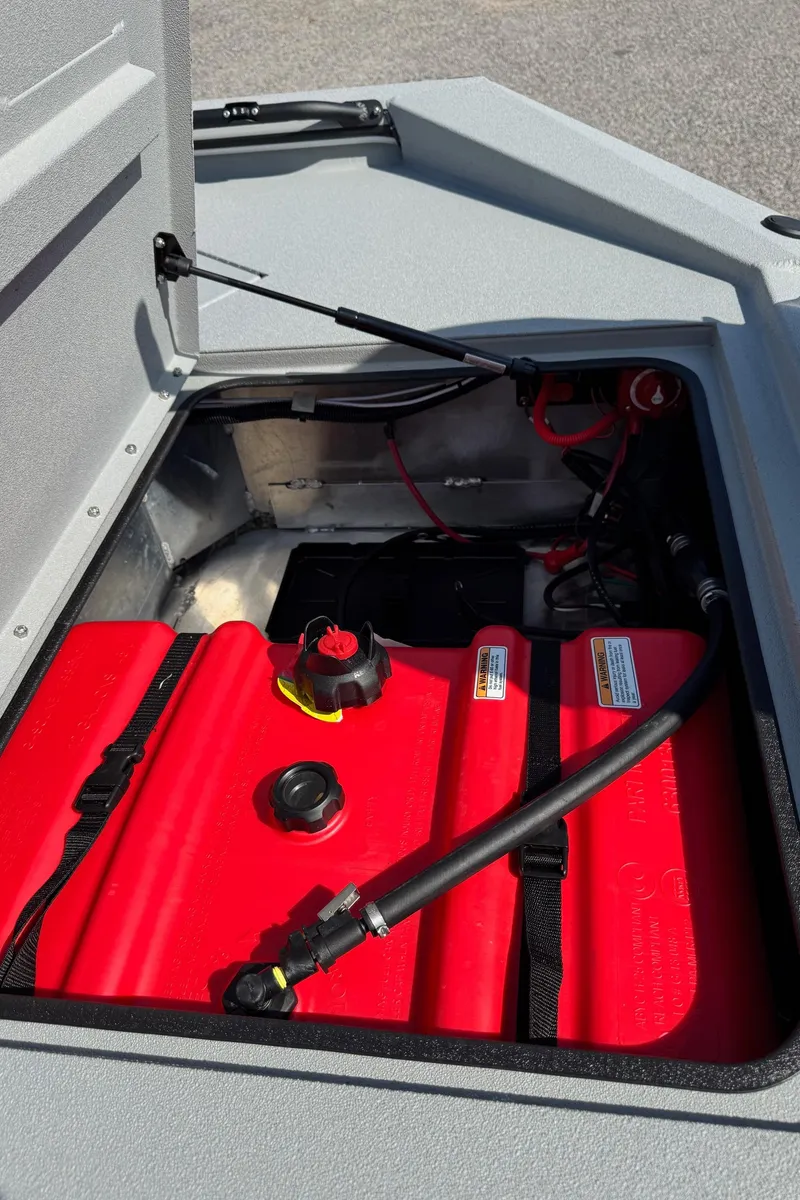 Slide: The Image of 2025 Avid 18 Commander boat fuel compartment with red fuel tank and hoses. - 17