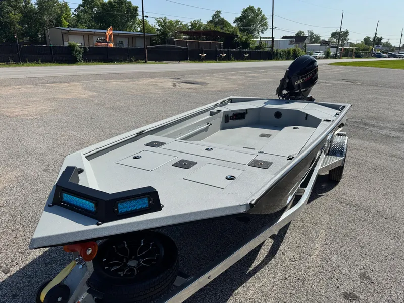 Slide: The Image of 2025 Avid 18 Commander boat on trailer, parked outdoors, featuring sleek design and modern outboard motor. - 5