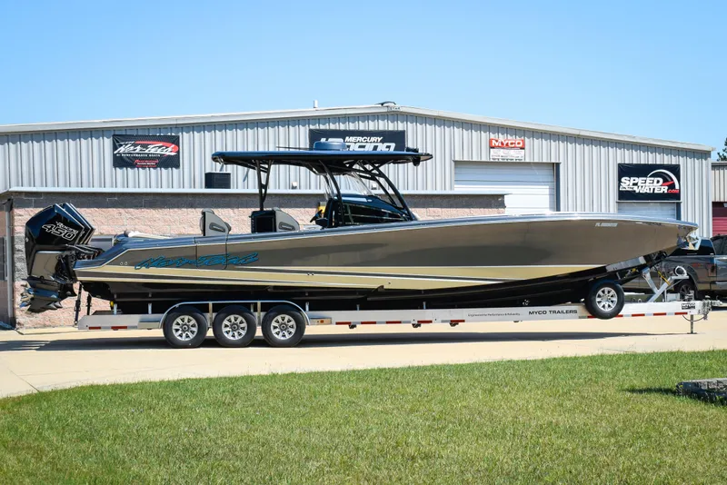Slide: The Image of 2022 Nor-Tech 390 Sport boat on trailer, parked outside a metal building. - 0