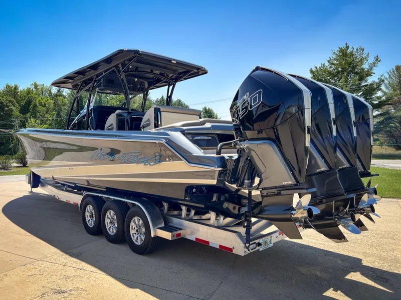 Slide: The Image of 2022 Nor-Tech 390 Sport boat on trailer with powerful outboard engines, parked outdoors. - 3