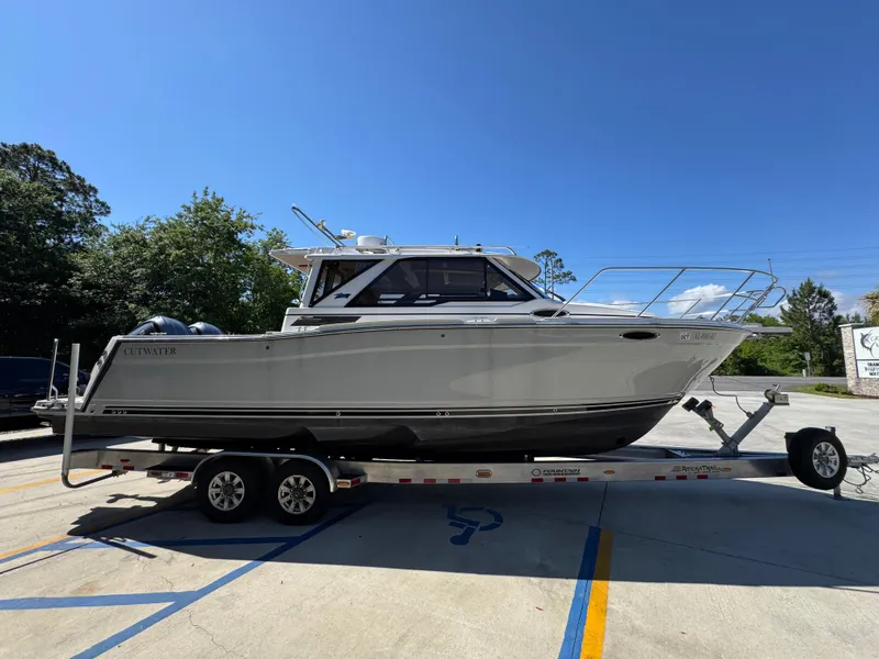 Slide: The Image of 2024 Cutwater C-288 Coupe boat on trailer under clear blue sky. - 12