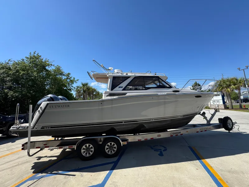 Slide: The Image of 2024 Cutwater C-288 Coupe boat on trailer under clear blue sky. - 13