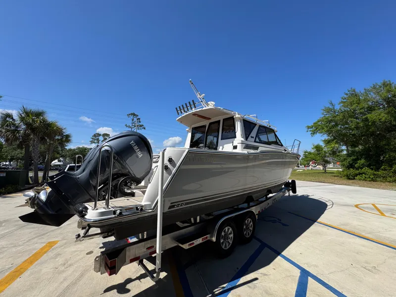 Slide: The Image of 2024 Cutwater C-288 Coupe boat on trailer under clear blue sky. - 14