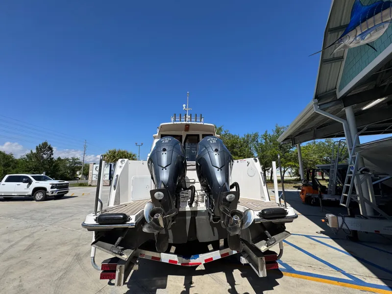 Slide: The Image of 2024 Cutwater C-288 Coupe boat with dual outboard engines, parked outdoors. - 18
