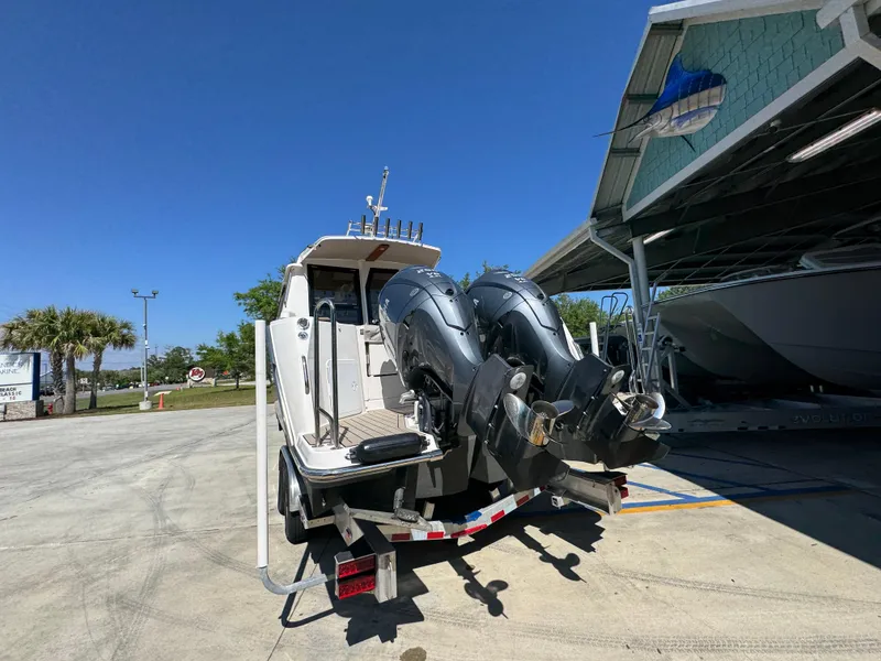 Slide: The Image of 2024 Cutwater C-288 Coupe boat with dual outboard motors on a trailer. - 19