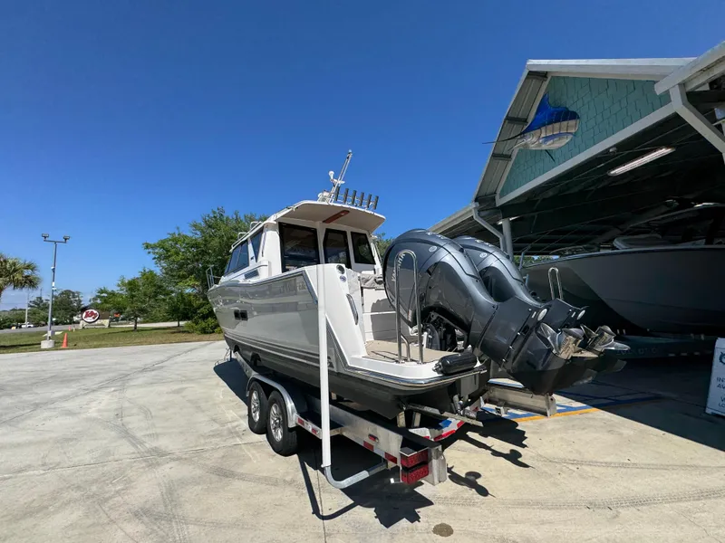 Slide: The Image of 2024 Cutwater C-288 Coupe boat on trailer, parked outdoors under clear blue sky. - 20