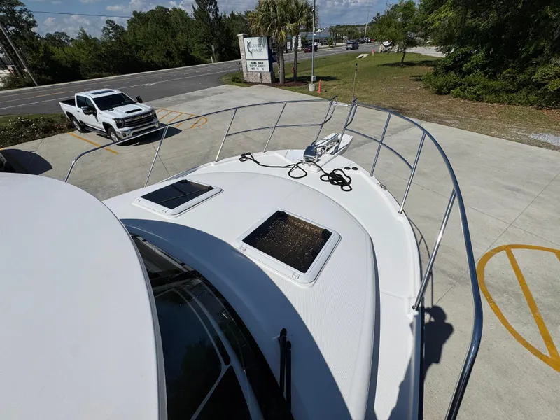 Slide: The Image of 2024 Cutwater C-288 Coupe boat deck with hatches, docked near a road. - 22