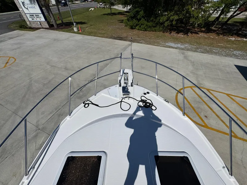 Slide: The Image of 2024 Cutwater C-288 Coupe boat deck with shadow and railing in a parking area. - 23