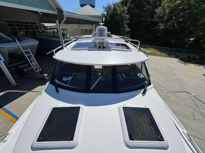 Slide: The Image of 2024 Cutwater C-288 Coupe boat with dual sunroofs, docked at a marina. - 27