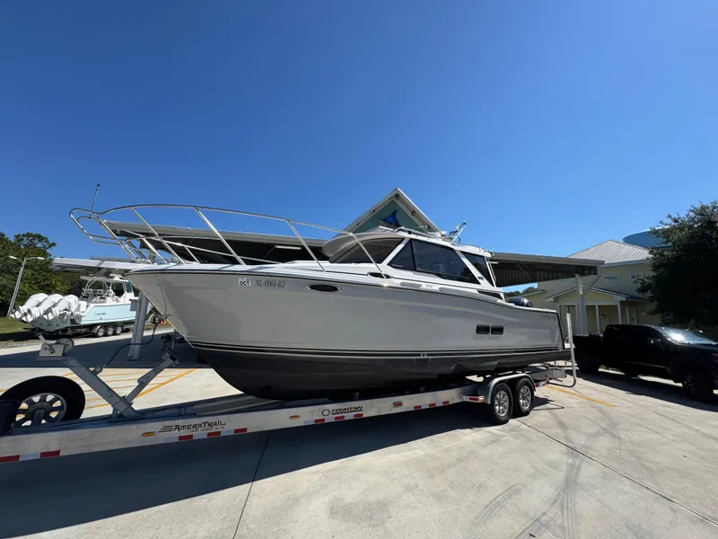 Slide: The Image of 2024 Cutwater C-288 Coupe boat on trailer under clear blue sky. - 3