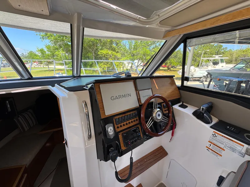 Slide: The Image of 2024 Cutwater C-288 Coupe helm with Garmin navigation system and wooden steering wheel. - 32