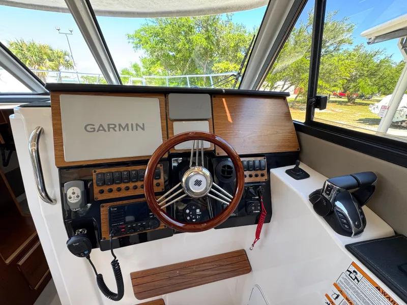 Slide: The Image of 2024 Cutwater C-288 Coupe helm with Garmin navigation, wooden accents, and modern controls. - 33