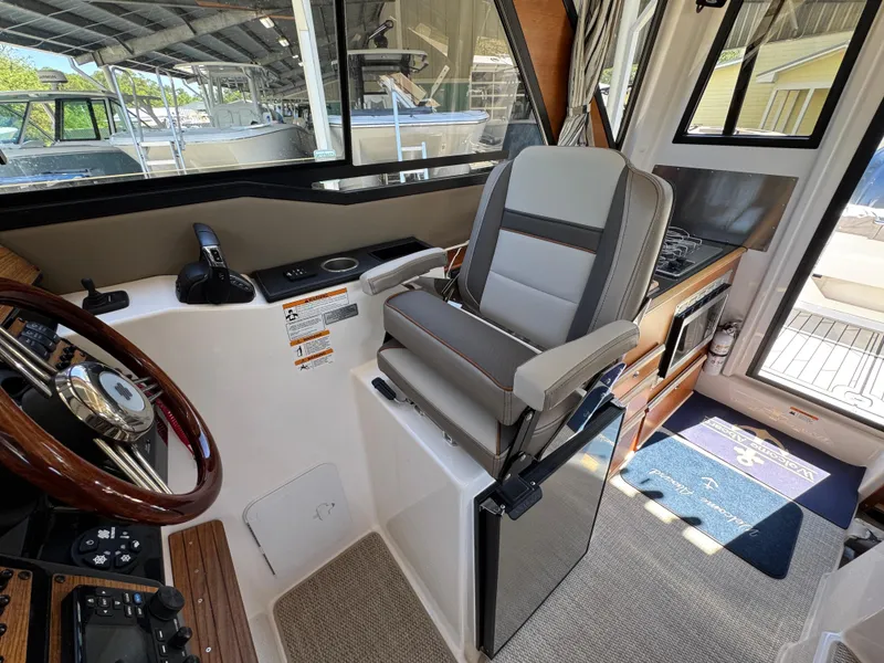 Slide: The Image of 2024 Cutwater C-288 Coupe interior with captain's chair and helm, showcasing modern design. - 37