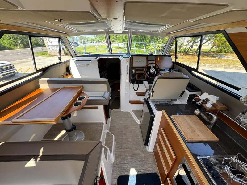 Slide: The Image of 2024 Cutwater C-288 Coupe interior with helm, seating, and kitchen area. - 44