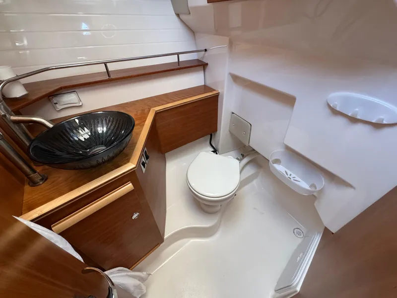 Slide: The Image of 2024 Cutwater C-288 Coupe bathroom with modern sink, toilet, and wooden cabinetry. - 48