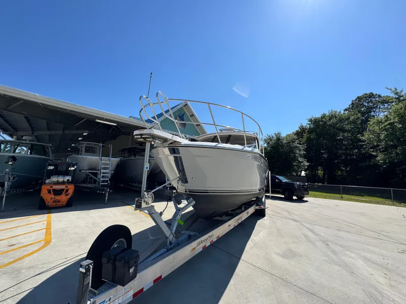 Slide: The Image of 2024 Cutwater C-288 Coupe boat on trailer in sunny outdoor setting. - 6