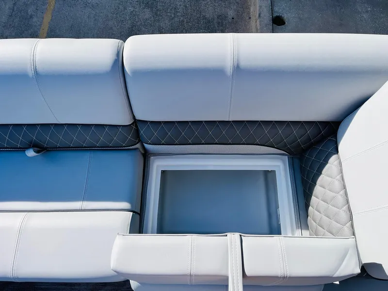 Slide: The Image of 2025 Ranger Reata 223FC boat seat with storage compartment, featuring white and gray upholstery. - 18