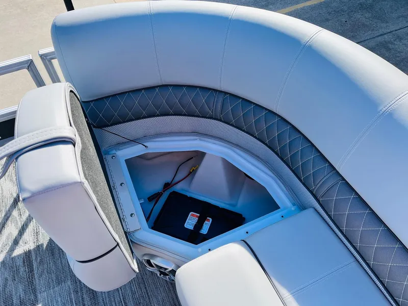 Slide: The Image of 2025 Ranger Reata 223FC boat seat storage compartment with quilted upholstery and open hatch. - 20