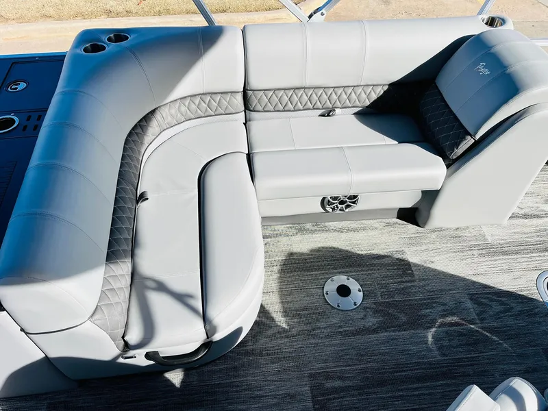 Slide: The Image of 2025 Ranger Reata 223FC boat interior with gray cushioned seating and cup holders. - 28