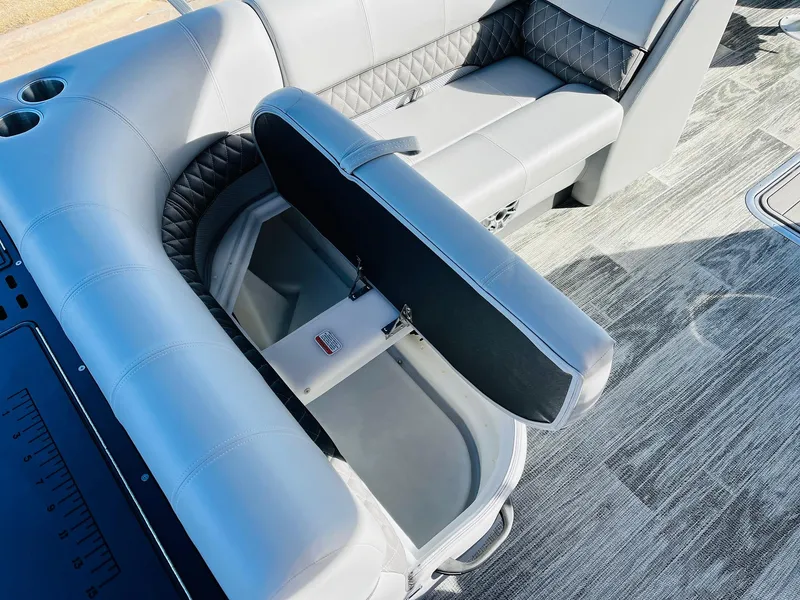 Slide: The Image of 2025 Ranger Reata 223FC boat interior with open storage compartment and cushioned seating. - 30