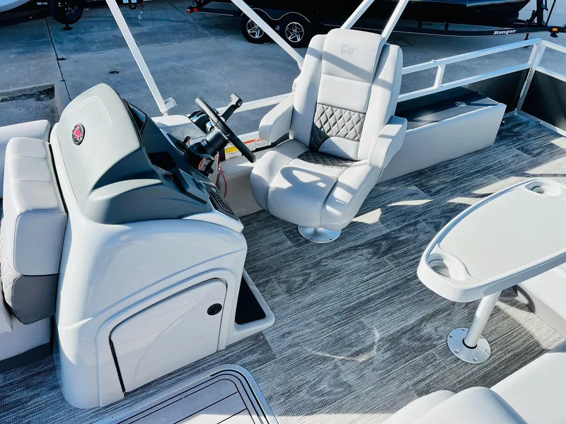 Slide: The Image of 2025 Ranger Reata 223FC boat interior with modern seating and steering console. - 32