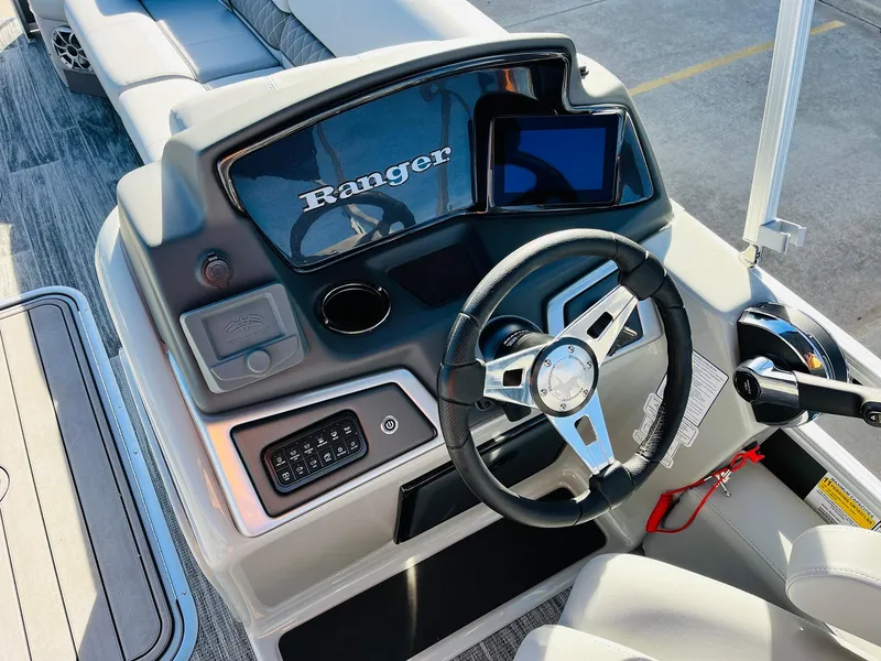 Slide: The Image of 2025 Ranger Reata 223FC boat dashboard with steering wheel and control panel. - 34