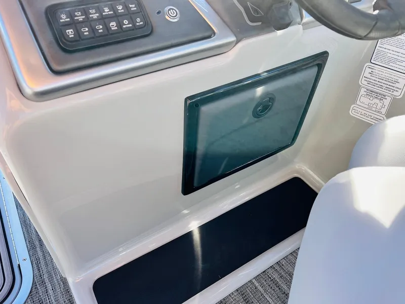 Slide: The Image of 2025 Ranger Reata 223FC boat console with control panel and storage compartment. - 36