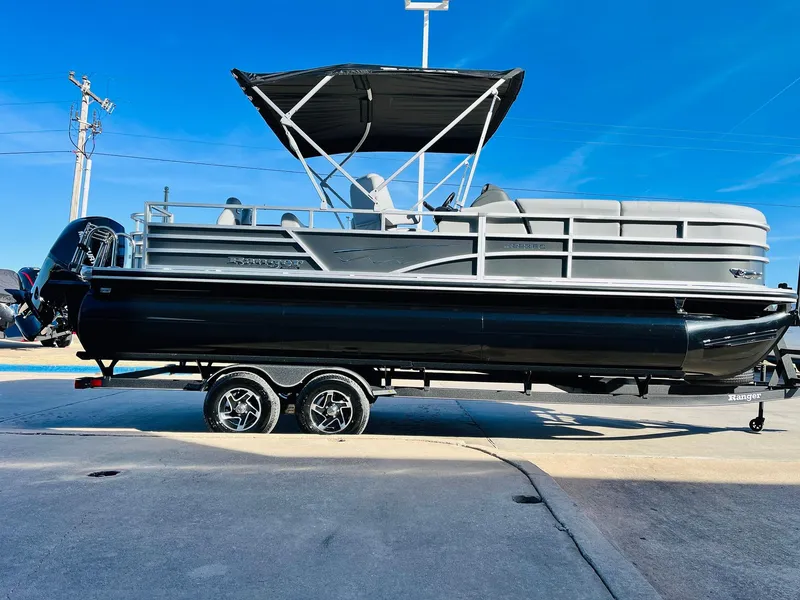 Slide: The Image of 2025 Ranger Reata 223FC pontoon boat on trailer, featuring sleek design and canopy. - 4