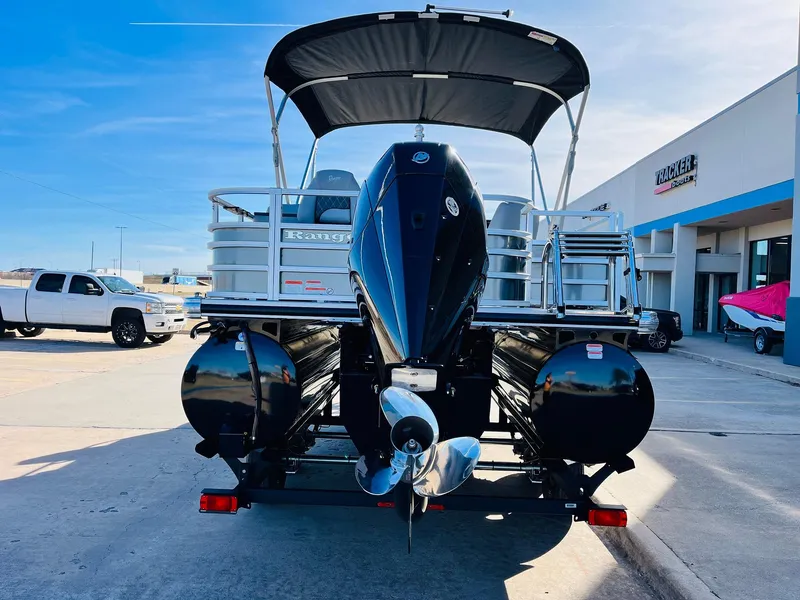 Slide: The Image of 2025 Ranger Reata 223FC pontoon boat with outboard motor, parked outdoors. - 6