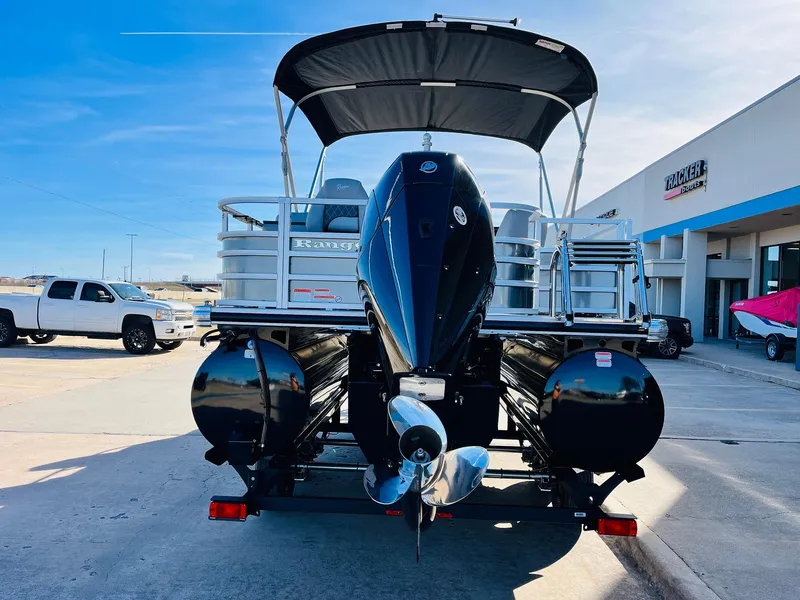 Slide: The Image of 2025 Ranger Reata 223FC pontoon boat with outboard motor, parked outdoors. - 7
