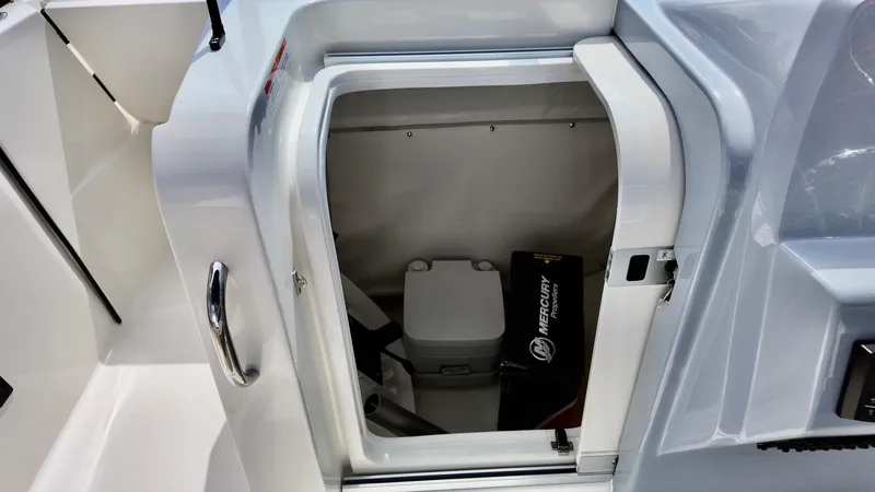 Slide: The Image of 2025 Bayliner Trophy 22 Side Console storage compartment with portable toilet and Mercury accessory box. - 10