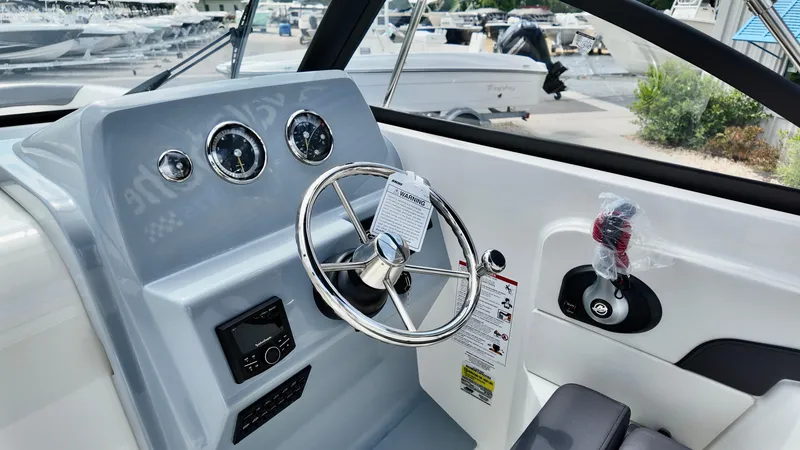 Slide: The Image of 2025 Bayliner Trophy 22 Side Console dashboard with steering wheel and controls. - 16
