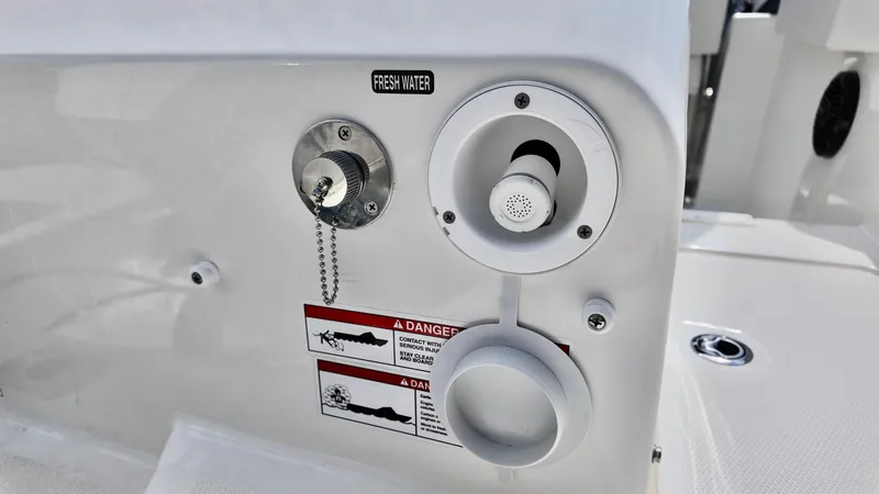 Slide: The Image of 2025 Bayliner Trophy 22 Side Console fresh water system controls and warning labels. - 6