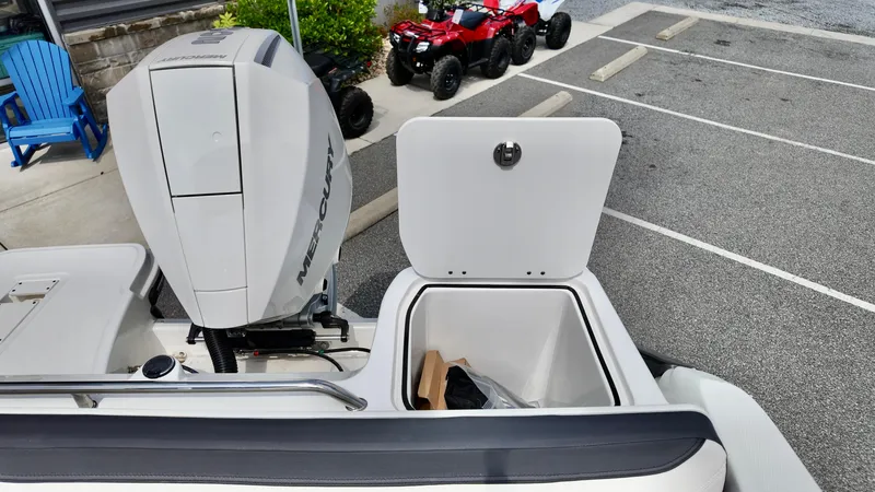 Slide: The Image of 2025 Bayliner Trophy 22 Side Console with open storage compartment and Mercury outboard engine. - 7