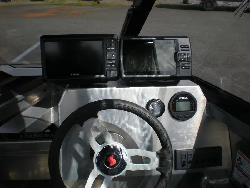 Slide: The Image of 2024 Stabicraft 1550 Fisher dashboard with Garmin displays and steering wheel. - 5