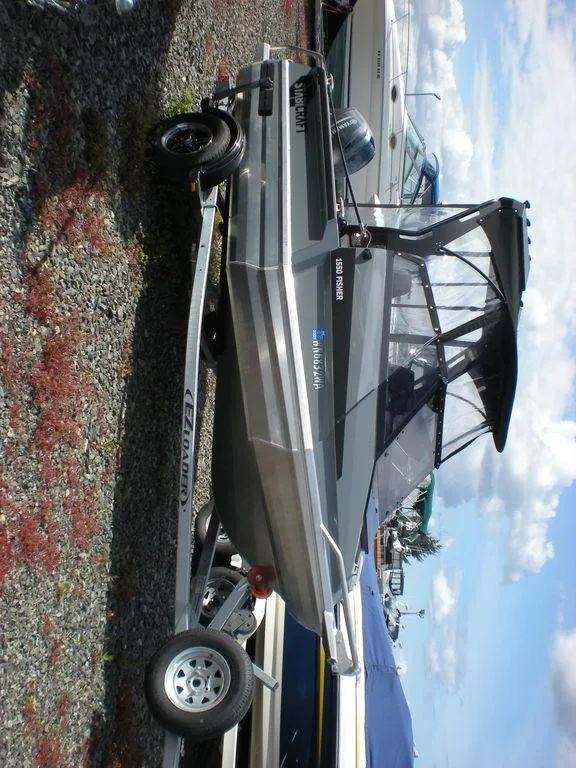 Slide: The Image of 2024 Stabicraft 1550 Fisher boat on trailer, parked outdoors under a clear sky. - 9