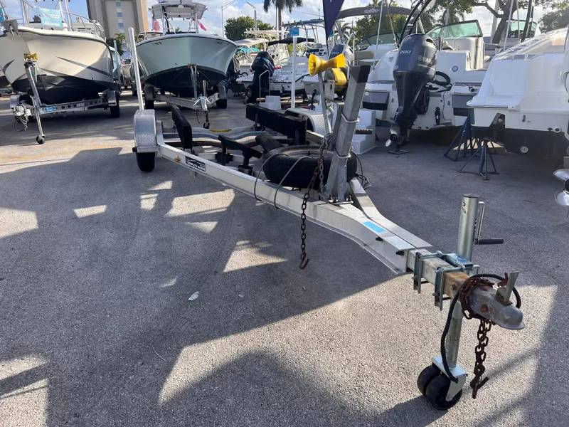 The Image of 2018 Nextrail 19-21 Tandem Axel trailer in a boatyard, surrounded by boats. - 0