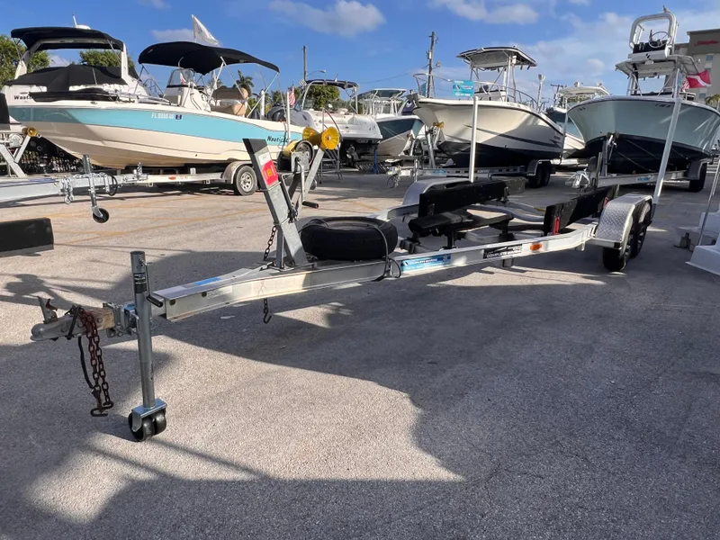 Slide: The Image of 2018 Nextrail 19-21 Tandem Axel trailer in a boatyard under clear skies. - 1