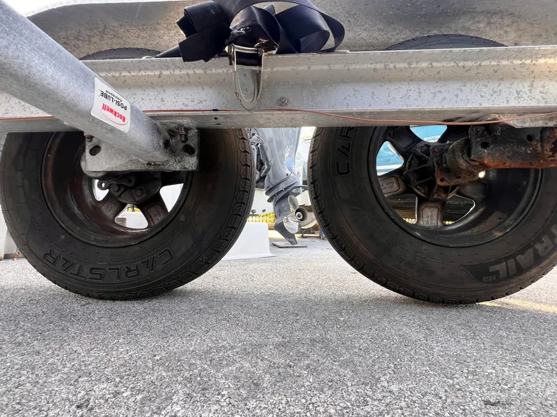 Slide: The Image of 2018 Nextrail 19-21 Tandem Axel trailer wheels on asphalt surface. - 7
