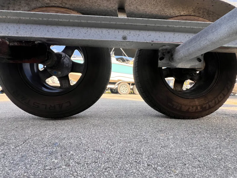 Slide: The Image of 2018 Nextrail 19-21 Tandem Axel trailer wheels on pavement, close-up view. - 8
