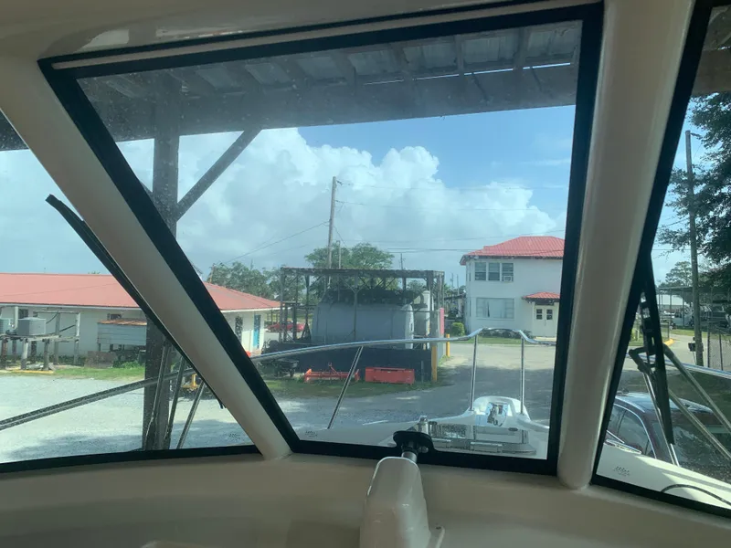 Slide: The Image of View from inside a 2008 Pursuit 315 OS boat, showing marina and buildings. - 11