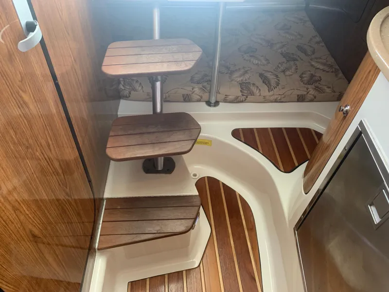 Slide: The Image of 2008 Pursuit 315 OS interior with wooden steps and patterned flooring. - 14